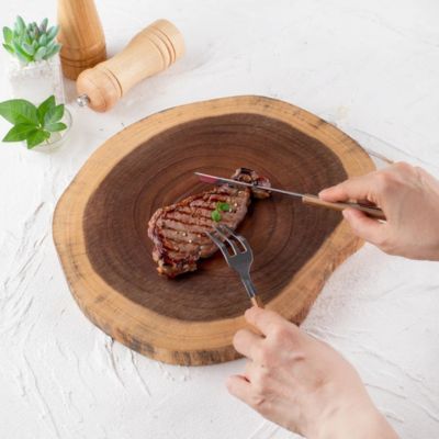 steak posé sur une planche à decouper en bois brut
