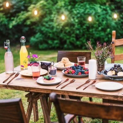 jolie table dressée dans le jardin avec des ustensiles de cuisine en bois