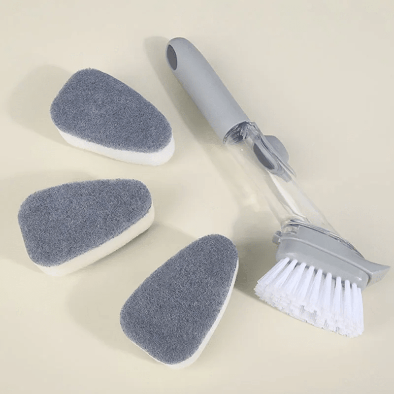 brosse à vaisselle grise posée sur un plan detravail jaune, avec 3 têtes en éponge plus une brosse