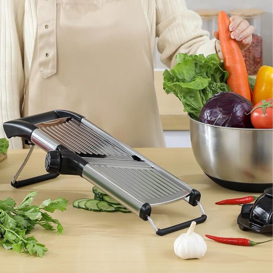 Mandoline cuisine réglable sur plan de travail avec légumes frais et gousse d’ail, idéale pour trancher finement.