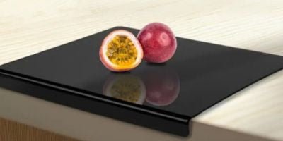 fruit de la passion coupé et posé sur une planche à découper acrylique noire