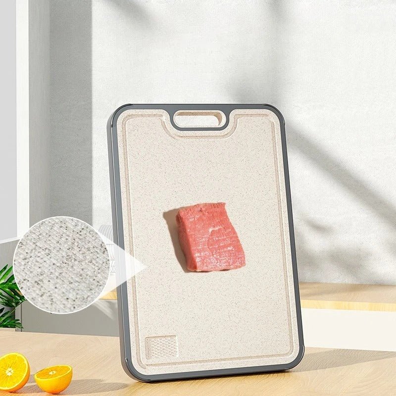 planche a decouper en titan verticale, avec un morceau de viande dessus, et deux demi citrons à côté, un grossissementde l'image montre la texture de la planche