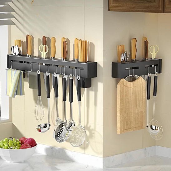 Porte-couteau mural multifonctions noir, avec couteaux, ustensiles, et gants suspendus accrochés sur deux rangées murales en cuisine.