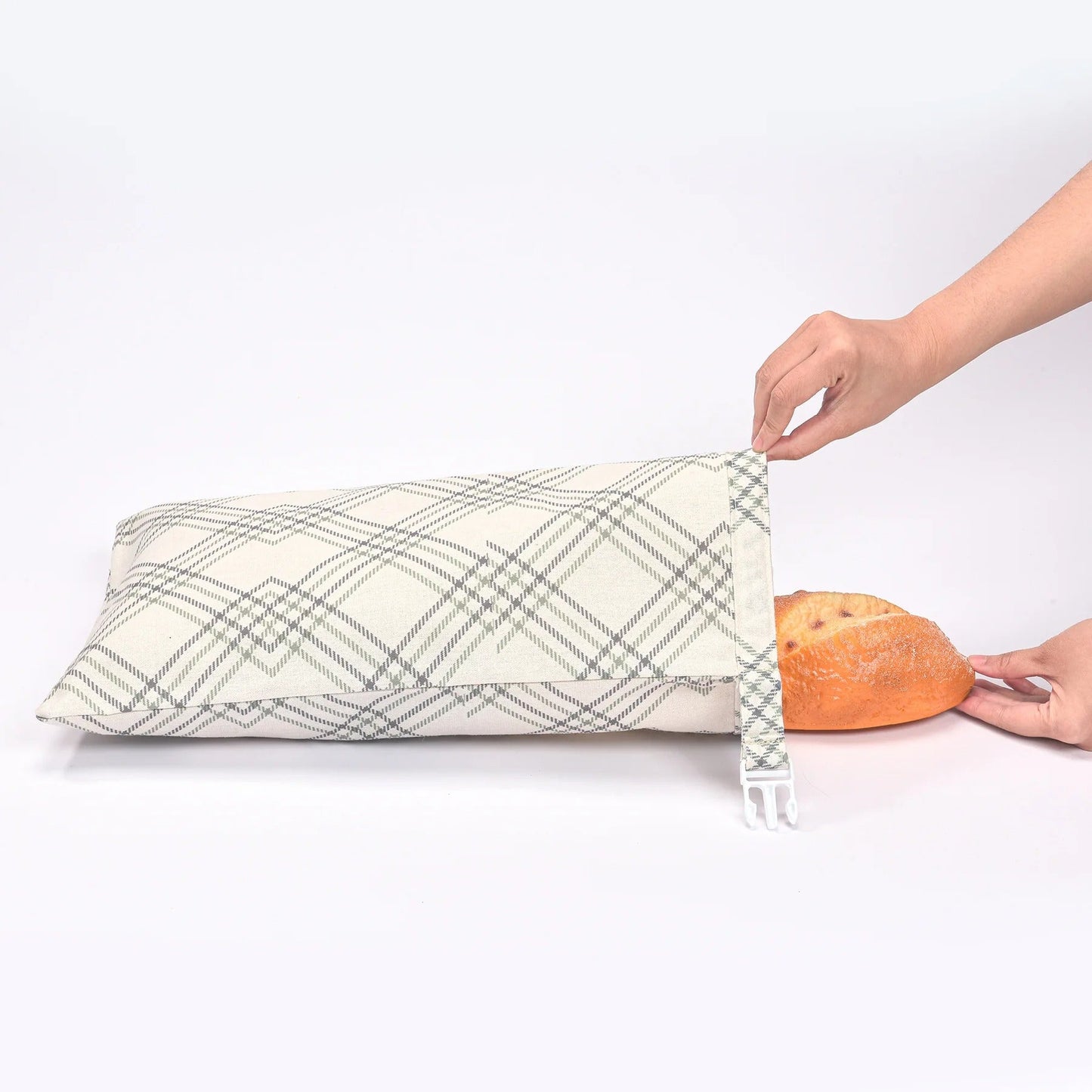 main de femme mettant une baguette dans un sac à pain blanc