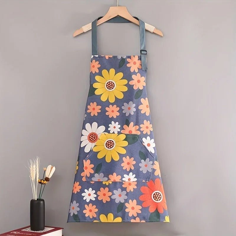 Tablier de cuisine fleuri bleu-violet avec grandes fleurs jaunes et roses, poche frontale, suspente réglable.