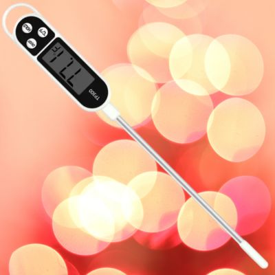 thermomètre de cuisson sur fond orange avec boules lumineuses jaunes