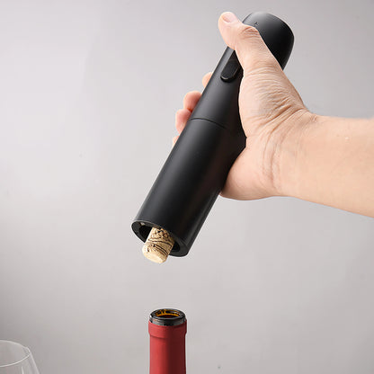 main tenant le tire bouchon electrique qui vient d'extraire un bouchon d'une bouteille de vin