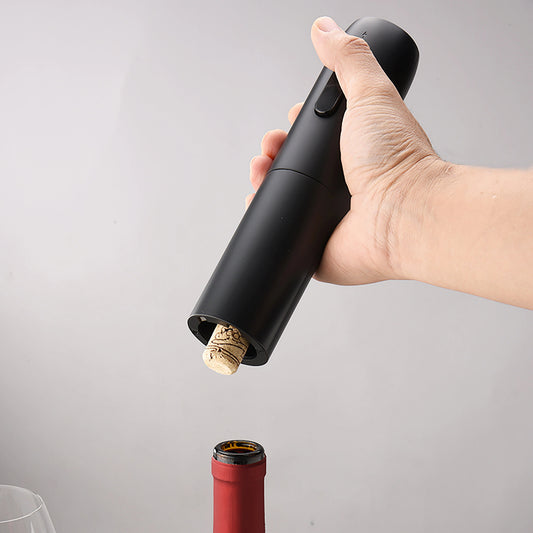 main tenant le tire bouchon electrique qui vient d'extraire un bouchon d'une bouteille de vin