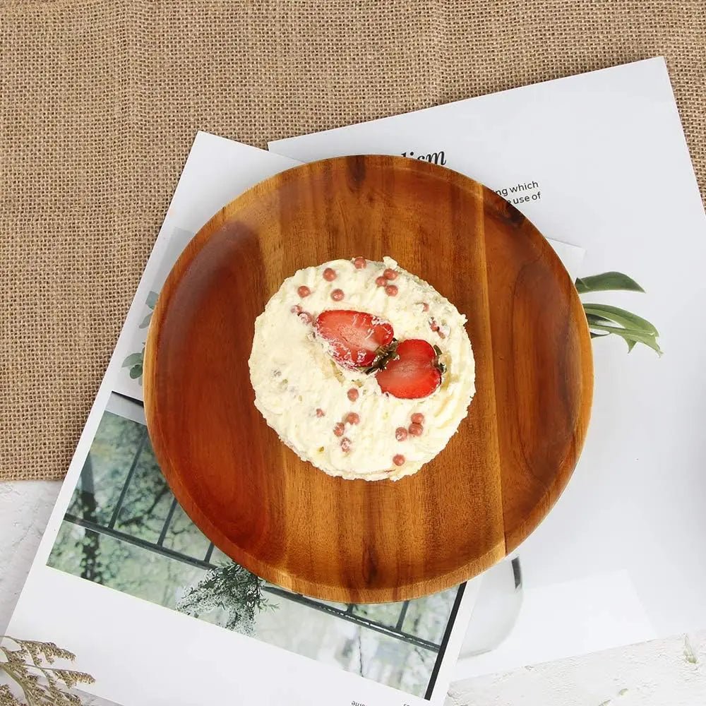 assiette en bois avec une tartelette aux fraises, posée sur un journal