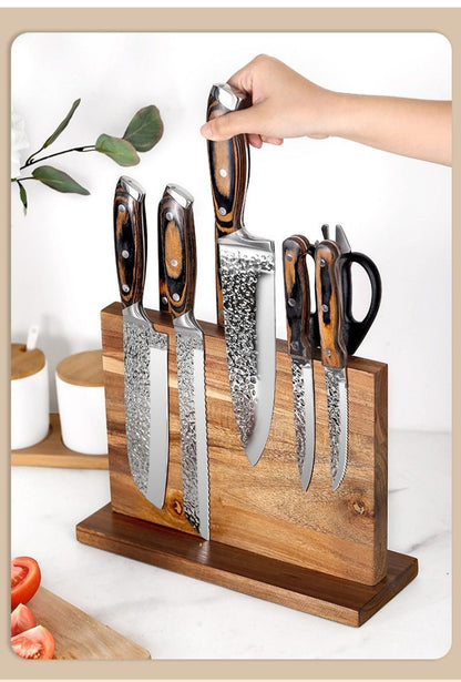 Porte-couteaux magnétique en acacia avec ensemble de couteaux à lames damassées et manches bois, posé sur support en bois.